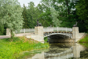 Fototapeta na wymiar The Russian Empire era Deer Bridge over the canal in Pavlovsky Park in Pavlovsk, Saint Petersburg, Russia