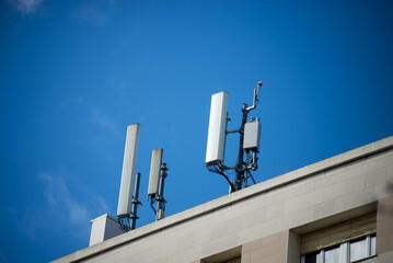 Closeup of telephone antenna relay on the roof of building on blue sky background