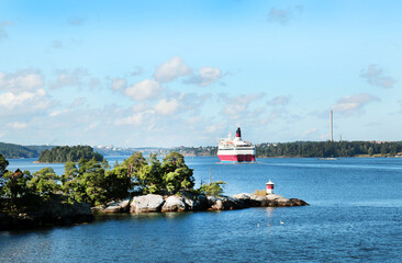 View of the islands and the shore in the bay with a sea liner near Stockholm on a clear sunny day. Travel landscape sights of Europe.
