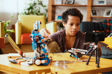 An educated little boy recording himself for a vlog and making a robot. Education in electronics and artificial intelligence.