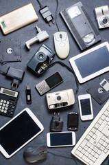 Old electronic devices on a dark background. The concept of recycling and disposal of electronic...
