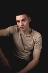 Fototapeta premium Handsome guy posing in studio on isolated black background. Studio portrait with one light source.