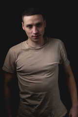 Fototapeta premium Handsome guy posing in studio on isolated black background. Studio portrait with one light source.