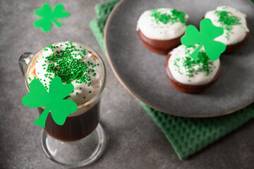 Irish coffee in shot glass cup and special cupcakes for St Patricks Day on gray table. Happy st Patrick day.