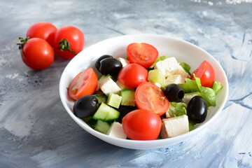 traditional greek salad with black olives, feta cheese, cucumber and cherry tomatoes in bowl, close-up