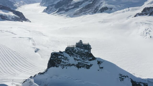 Aerial view of Jungfraujoch, a building on mountain crest with snow on Swiss Alps, Wengen, Bern, Switzerland.