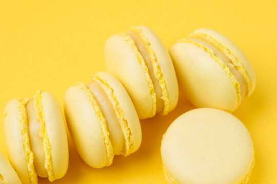 Pile of lemon macarons on yellow background