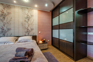 Interior of the modern luxure bedroom with pillows on the bed in studio apartments in light color style
