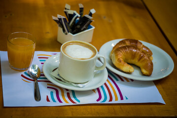 coffee with milk, orange juice and croissants