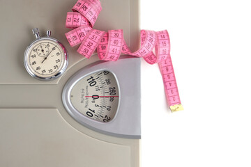 Floor scales, stopwatch and measuring tape on a white background.Weight loss and sports.