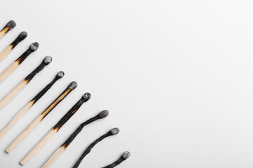 Burnt wooden matches on white background, closeup. Concept of different human life phases