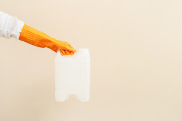 Male hands in rubber gloves holding canister on light background