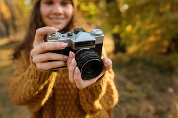 Female photographer with photo camera in autumn forest