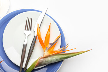 Simple table setting with bird of paradise flowers on white background