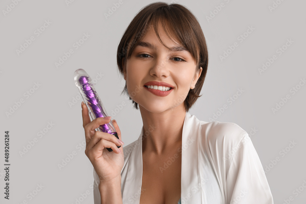 Canvas Prints beautiful young woman with vibrator from sex shop on grey background