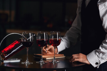 Young male sommelier tasting types of wine