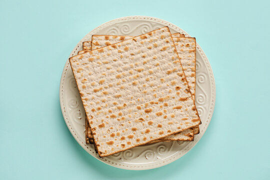 Plate with Jewish flatbread for Passover on color background