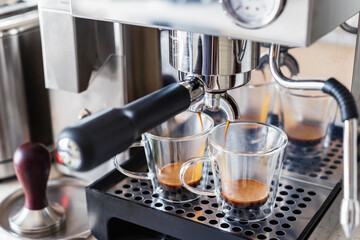 Espresso coffee in glass cups in coffee machine.