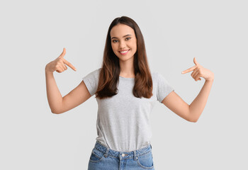 Pretty young woman in stylish t-shirt on light background
