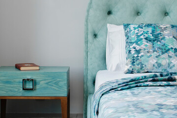 bedroom in soft light colors, turquoise. Bedside table next to the bed in an elegant classic bedroom