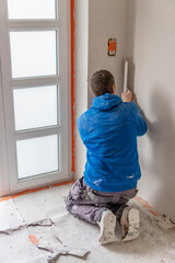 Ouvrier mettant du plâtre sur un mur intérieur d'une maison