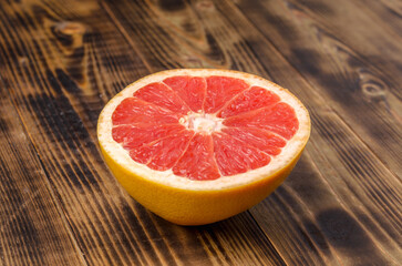 Cut grapefruit half on wooden table.
