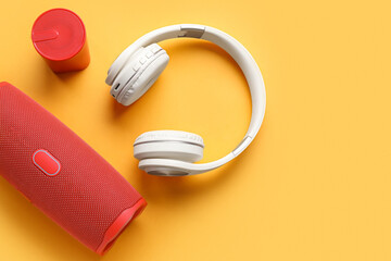 Wireless portable speakers and headphones on color background