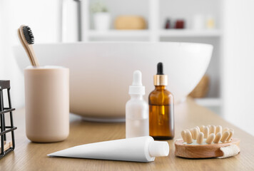 Fototapeta na wymiar Toothpaste and massage body brush on table in bathroom