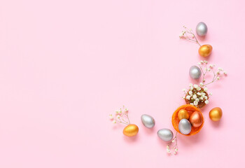 Composition with Easter eggs and flowers on pink background
