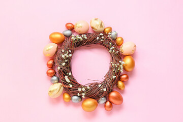 Composition with wreath and Easter eggs on pink background