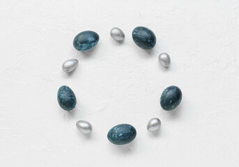 Frame made of Easter eggs on light background