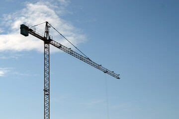 High steel crane at construction site blue sky