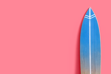 Wooden surfboard near pink wall