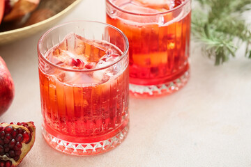 Glasses of tasty pomegranate cocktail on white background