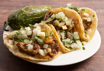 Three Delicious Buche Street Tacos in a Row on a Wooden Table