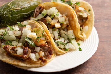 Three Delicious Buche Street Tacos in a Row on a Wooden Table