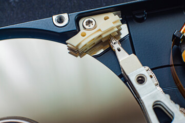 Macro view of an HDD head resting on a disk platter and its reflection