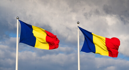 Flag of Romania winding against a spectacular cloudy blue sky