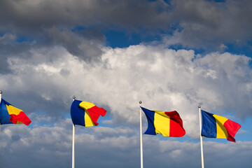 Flag of Romania winding against a spectacular cloudy blue sky