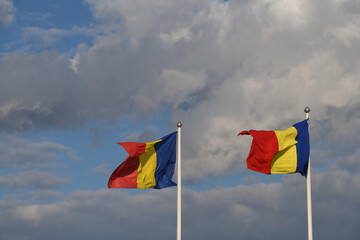 Flag of Romania winding against a spectacular cloudy blue sky