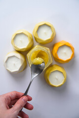 the top view of candles and a spoonful of honey on a white background looks like a flower.
