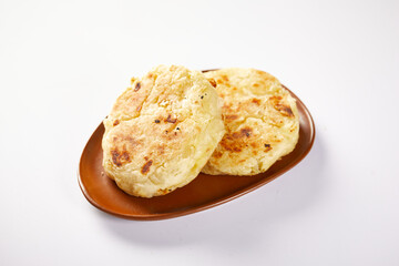 Tortilla de yuca a traditional Ecuadorian appetizer served with coffee. It’s on a white background.