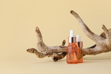 Bottles of natural cosmetic product with herbal extract on color background