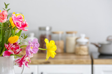 Beautiful tulips in light kitchen, closeup