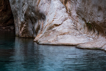 clean calm river with rocky banks at the bottom of a deep canyon
