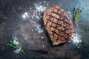 Barbecue dry aged entrecote double beef steak with salt and herbs served as top view on a rustic...