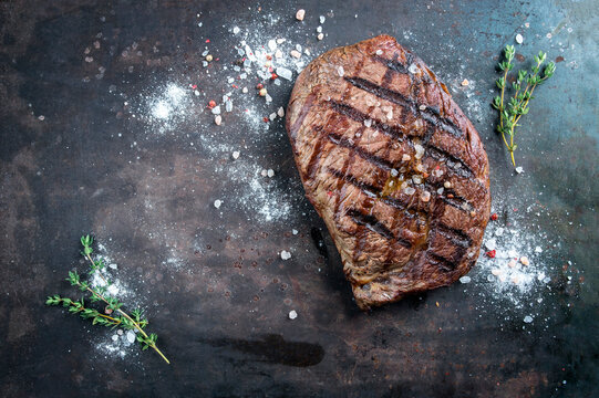 Barbecue dry aged entrecote double beef steak with salt and herbs served as top view on a rustic board