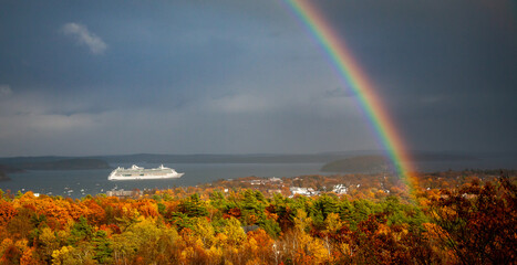A cruise ship under a brilliant rainbow in Mt Desert Narrows off the coast of Acadia National Park, Maine.