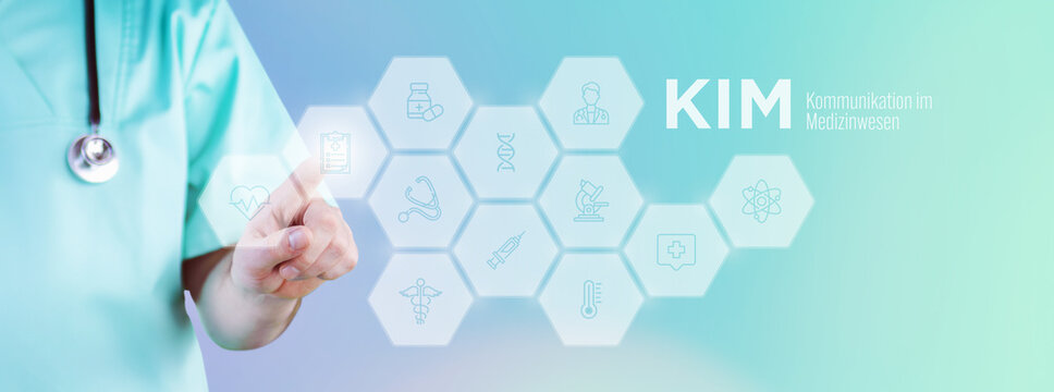 Kommunikation im Medizinwesen (KIM). M&auml;nnlicher Arzt zeigt mit Finger auf digitales Hologramm aus Icons. Text mit medizinischen Begriff. Konzept f&uuml;r Digitalisierung in der Medizin