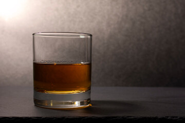 glass goblet with whiskey on a dark background